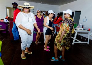 Moments at Mr Biodun Awosika's 60th birthday beach party showing guests dancing.